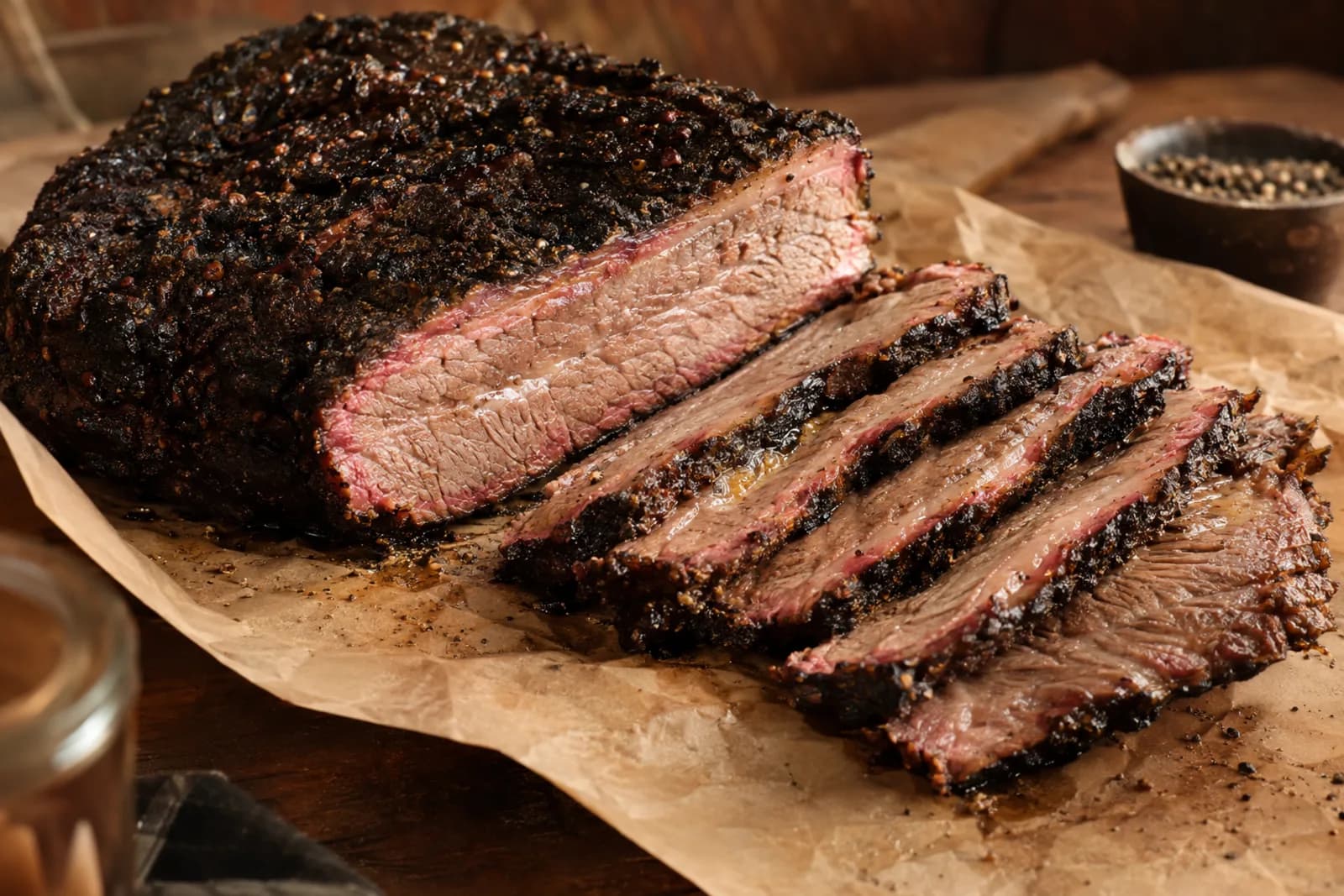 Dunkel geräuchertes Brisket mit saftigen Scheiben auf einem Holzbrett