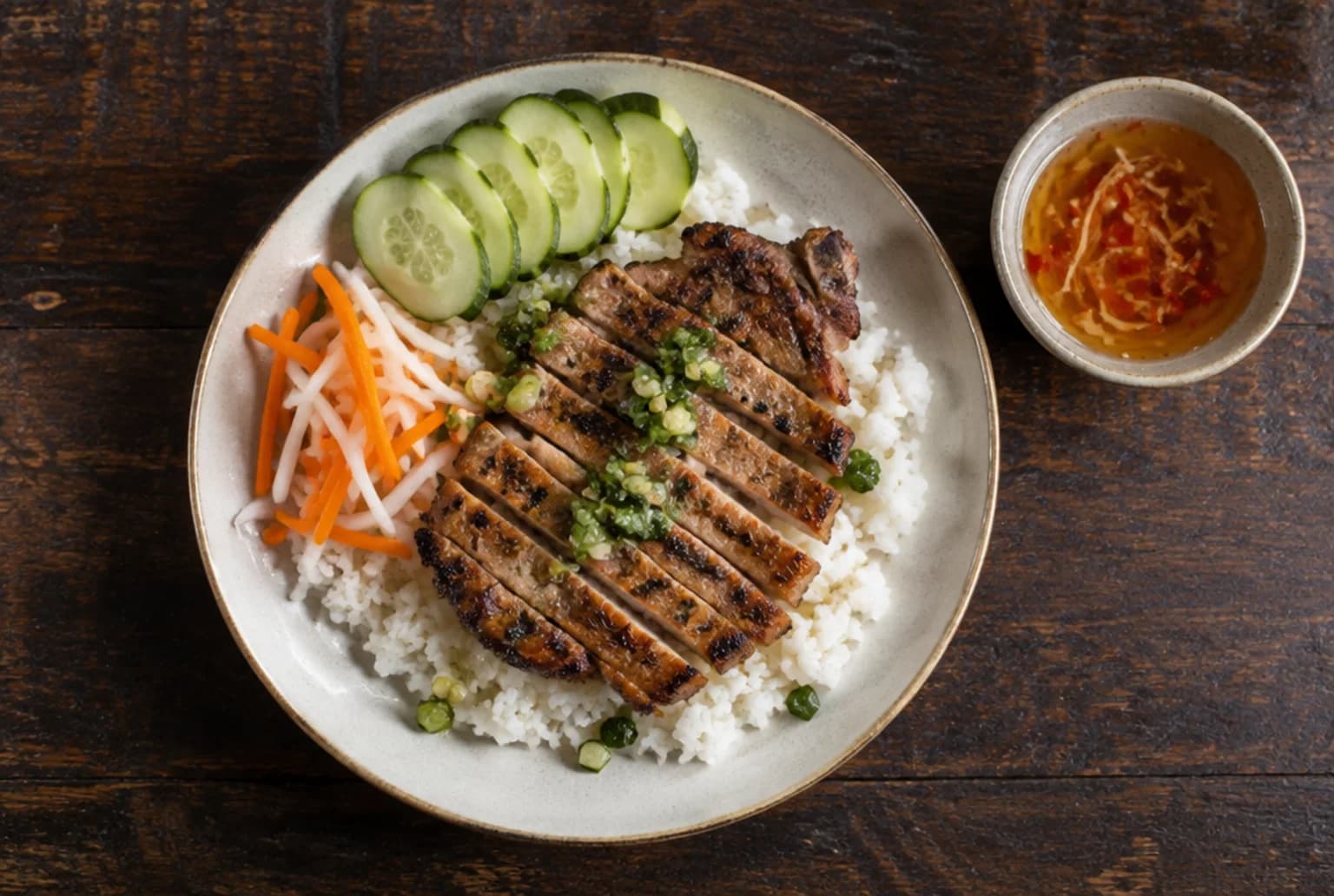 Teller Com Tam mit Broken Rice, geschnittenem gegrilltem Schweinekotelett, Frühlingszwiebelöl und Nuoc Cham