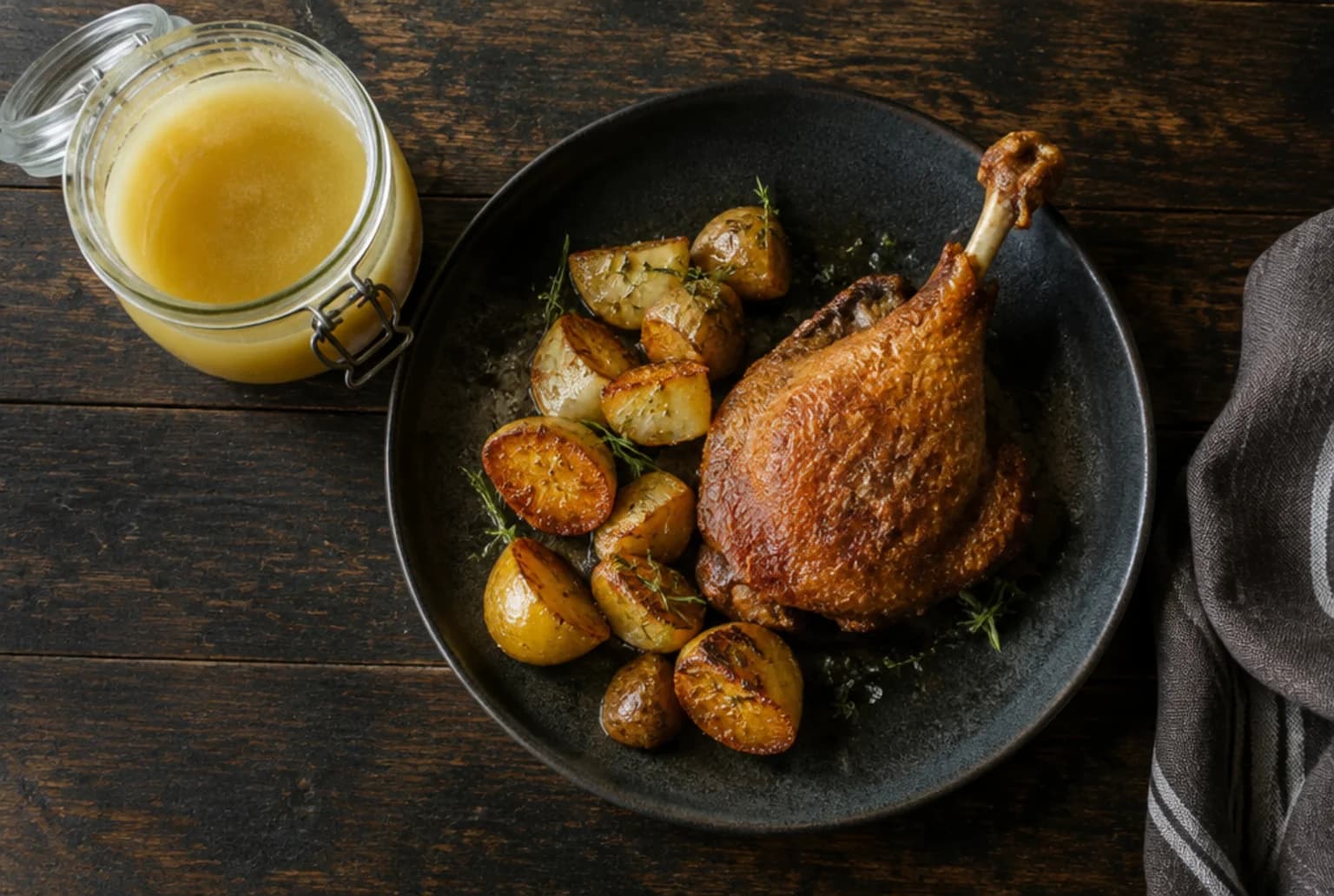 Confit de Canard: konfierte Entenkeule mit knuspriger Haut auf der Platte mit Kartoffeln