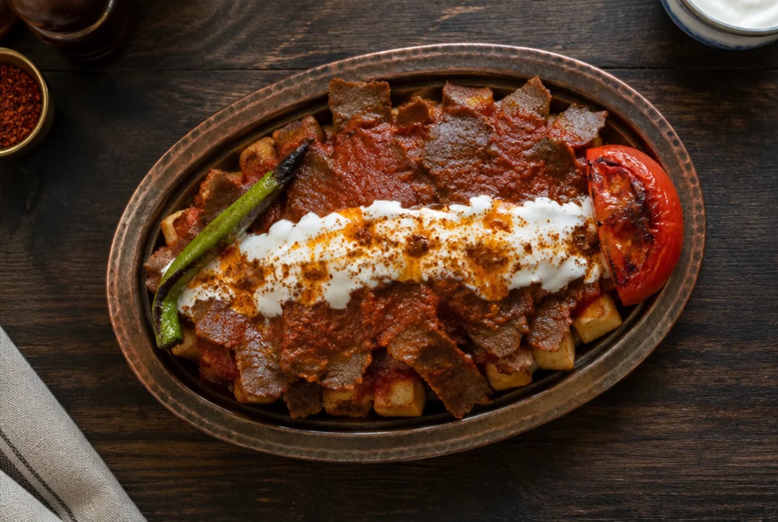 Iskender Kebab: Dönerscheiben auf Pide mit Tomatensauce, Joghurt und brauner Butter