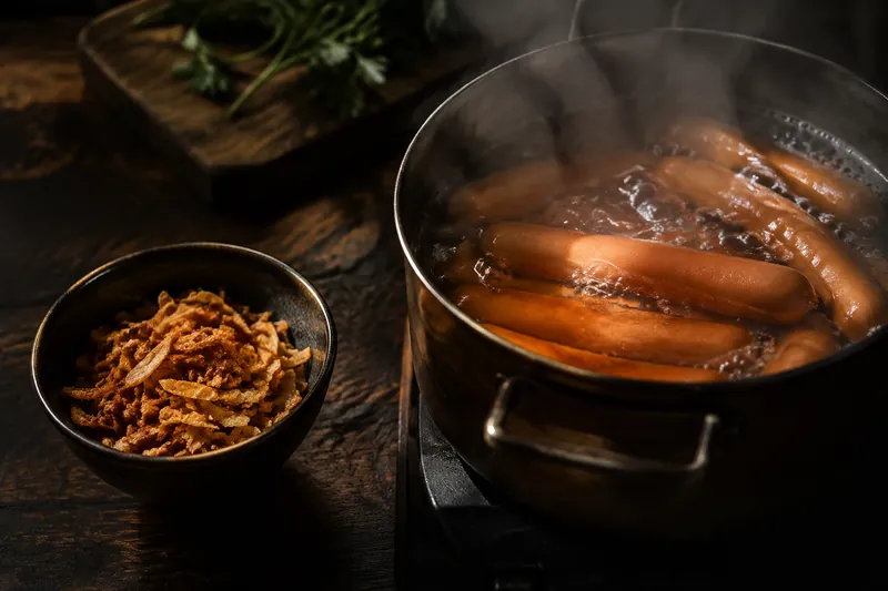 Schalotten braten und Würstchen ziehen