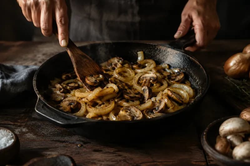 Zwiebeln und Champignons andünsten