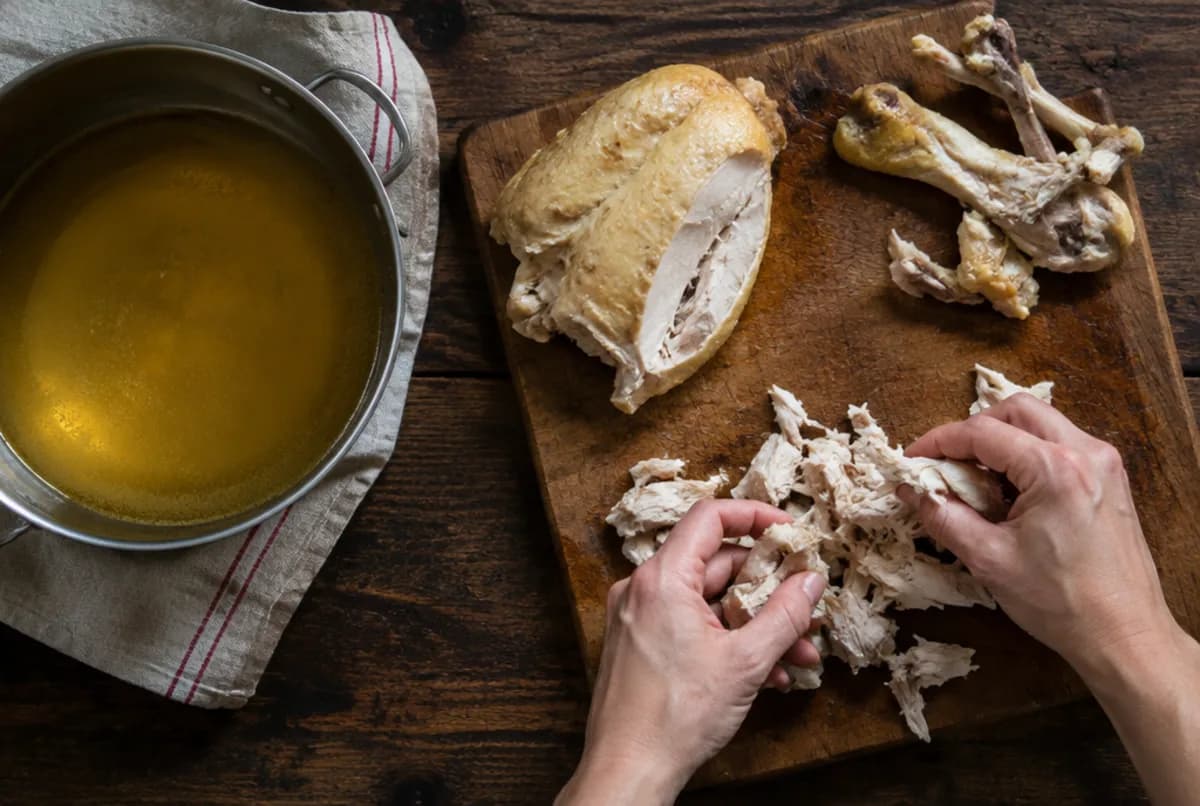 Fleisch zupfen und Brühe behalten