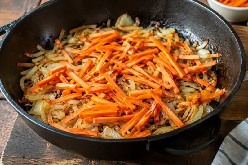 Zwiebeln und Rüebli braten