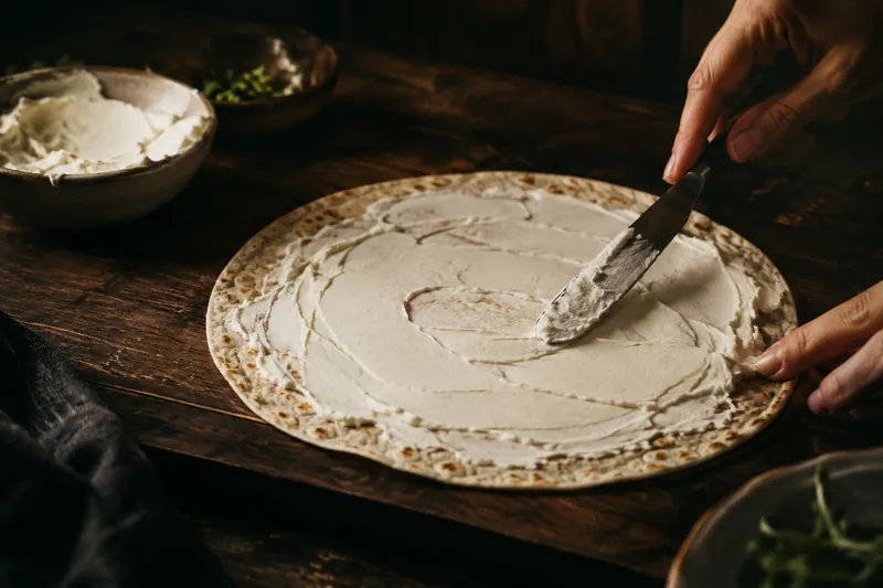Tortilla mit Frischkäse bestreichen